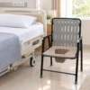 Commode chair with padded armrests and brown seat