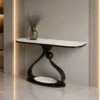 Modern console table with white veined marble-look top, sculptural black base and lower shelf